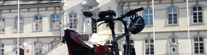 Fahrrad mit Helm und Tasche vor dem historischen Rathaus in Lippstadt